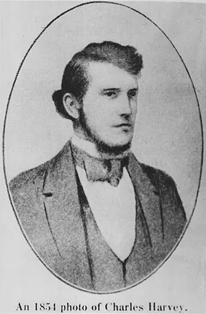 An oval portrait of a young man with sideburns along his jaw, wearing a high collar and suit.