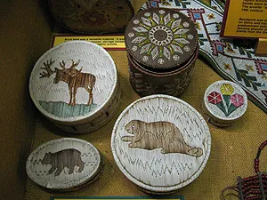 Five birch bark quillboxes decorated with quillwork depictions of a moose, beaver, bear, and geometric floral patterns.